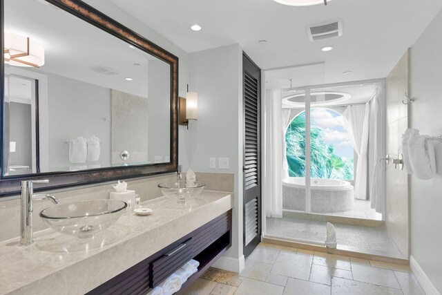 bathroom with vanity and tiled bath