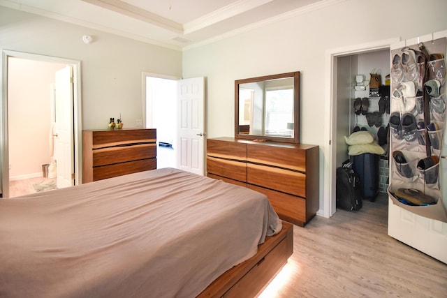 bedroom with crown molding, light hardwood / wood-style floors, and ensuite bathroom