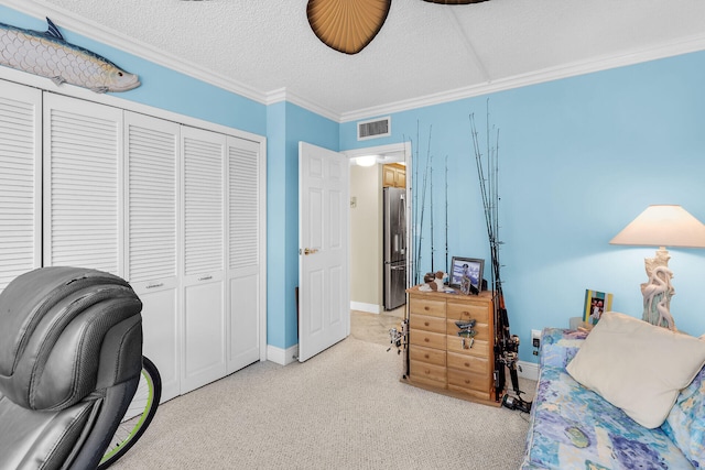 carpeted bedroom with a closet, ornamental molding, stainless steel refrigerator, and a textured ceiling