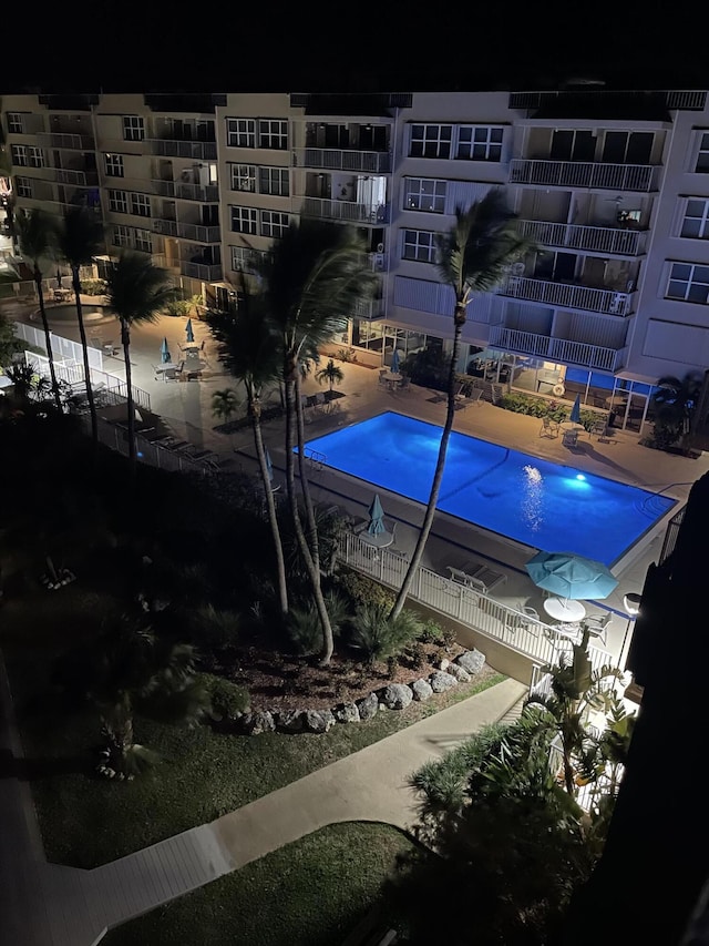 pool at twilight featuring a patio area