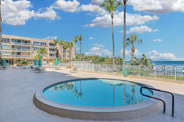 view of pool featuring a patio area and a water view