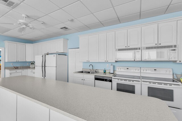 kitchen featuring sink, white cabinetry, ceiling fan, white appliances, and a drop ceiling