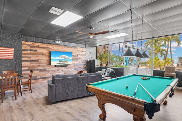 playroom with pool table, light hardwood / wood-style flooring, wooden walls, and ceiling fan