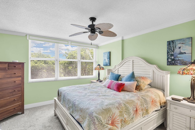 carpeted bedroom featuring ceiling fan, ornamental molding, and a textured ceiling