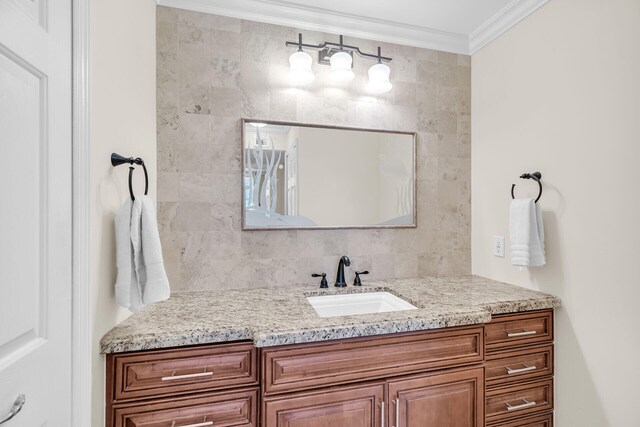 bathroom with crown molding, vanity, and backsplash