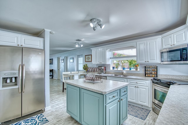 kitchen featuring a kitchen island, appliances with stainless steel finishes, sink, white cabinets, and light hardwood / wood-style floors