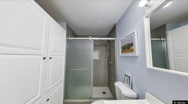 bathroom featuring vanity, an enclosed shower, and toilet