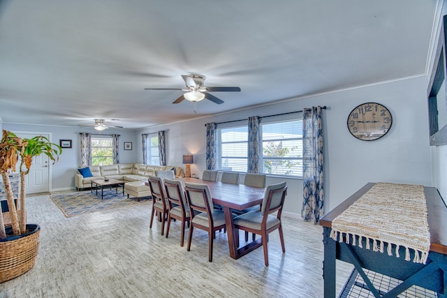 dining room featuring ceiling fan, light wood-type flooring, and baseboards