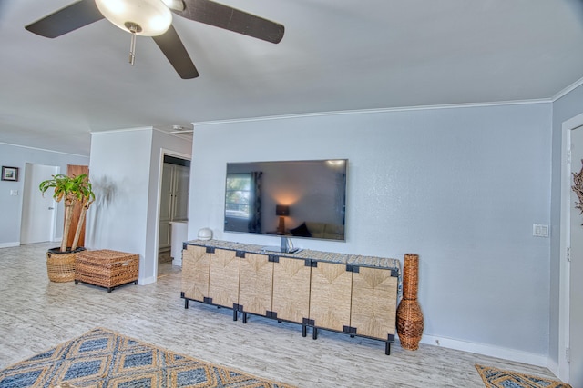 living area featuring ceiling fan, baseboards, and ornamental molding