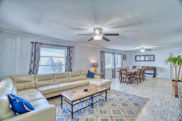 living room with baseboards, ceiling fan, and ornamental molding