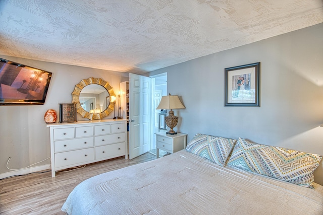 bedroom featuring light hardwood / wood-style flooring and a textured ceiling