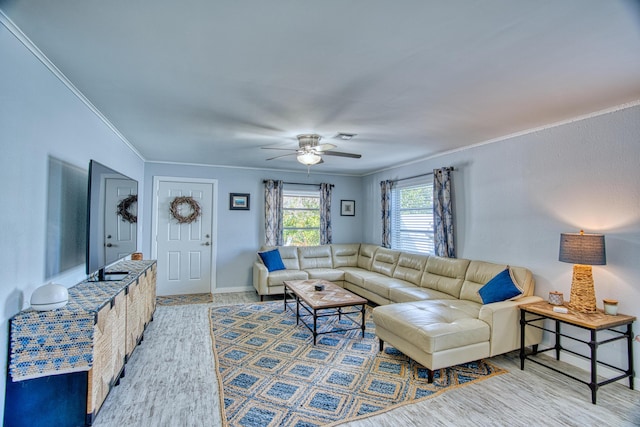 living area featuring visible vents, baseboards, crown molding, and a ceiling fan