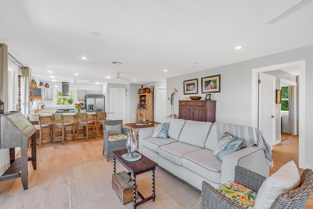 living room with light hardwood / wood-style flooring and ceiling fan