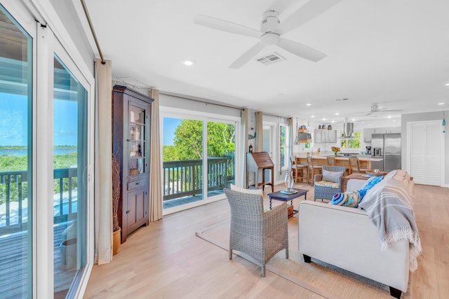 living room featuring ceiling fan and light wood-type flooring