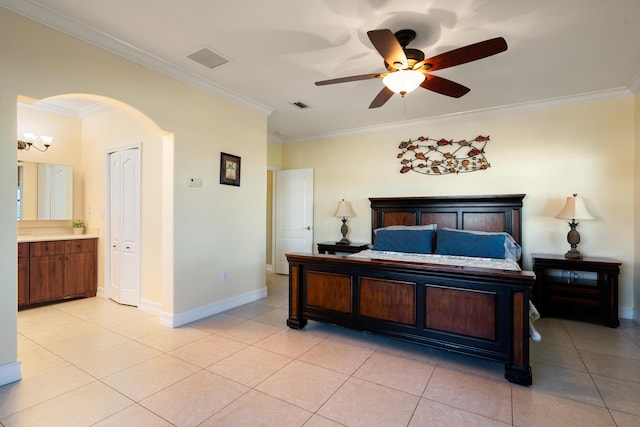 tiled bedroom with ornamental molding, connected bathroom, and ceiling fan