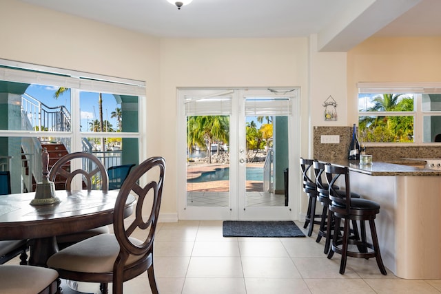 dining room featuring light tile patterned floors and french doors