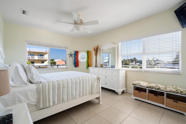 bedroom with multiple windows, light tile patterned floors, and ceiling fan