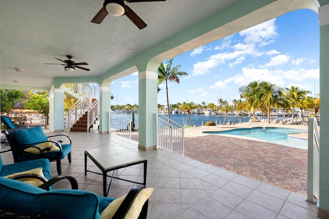 view of patio featuring a water view and ceiling fan