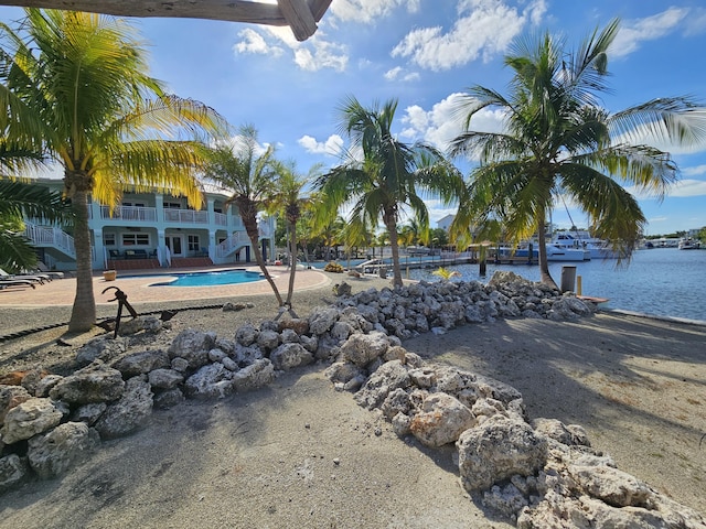 view of swimming pool with a water view and a patio area