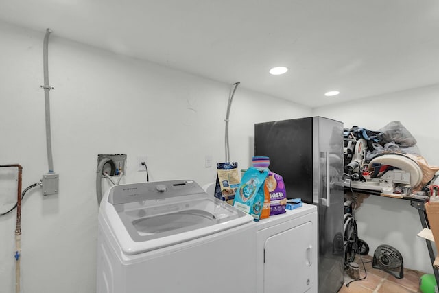 laundry room with washing machine and clothes dryer and light tile patterned flooring