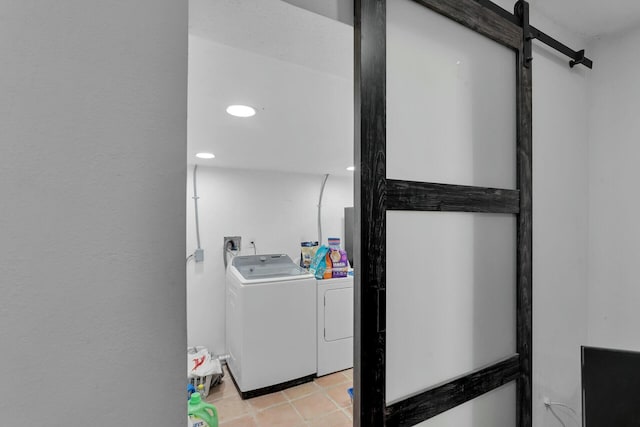 clothes washing area featuring washer and clothes dryer and light tile patterned floors