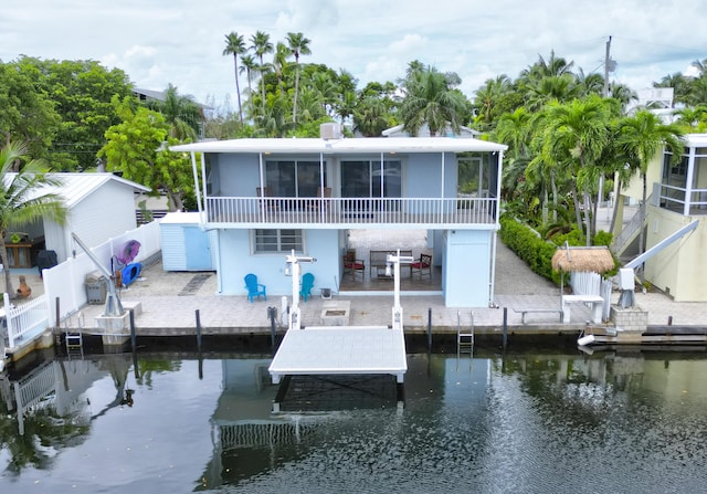 back of house featuring a patio area, a sunroom, and a water view