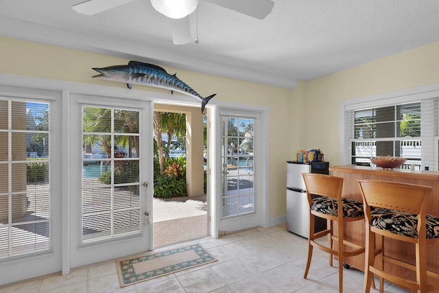 tiled dining area featuring a ceiling fan and a healthy amount of sunlight