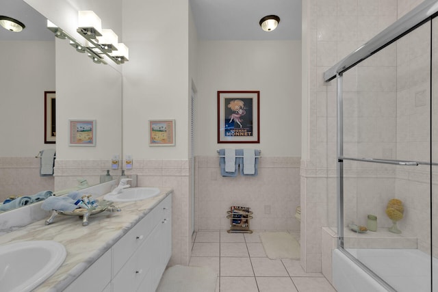 bathroom with a sink, toilet, tile walls, and tile patterned floors