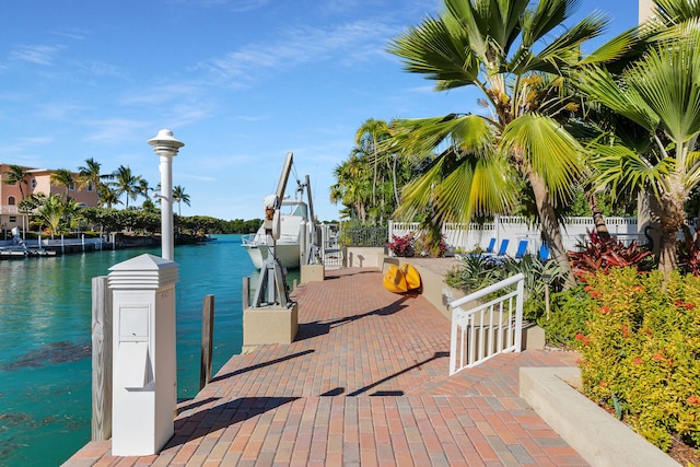 dock area with fence and a water view