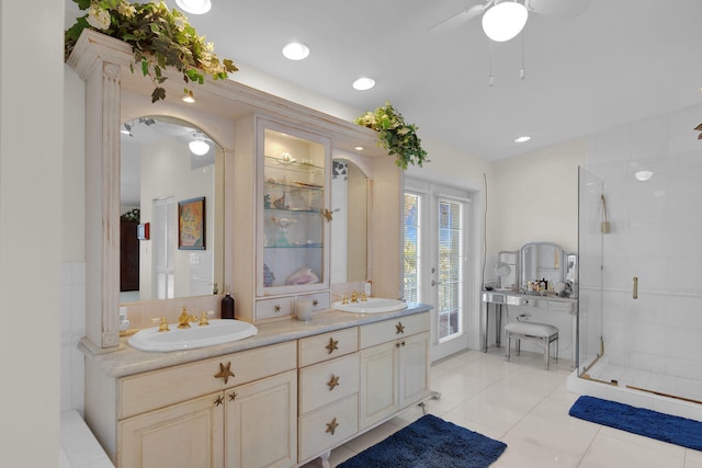 bathroom with a sink, a stall shower, double vanity, and ceiling fan