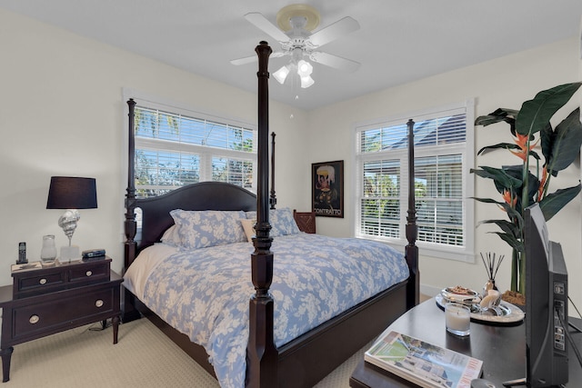 bedroom with baseboards, multiple windows, light colored carpet, and ceiling fan