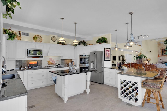 kitchen with decorative backsplash, a breakfast bar area, visible vents, and stainless steel appliances