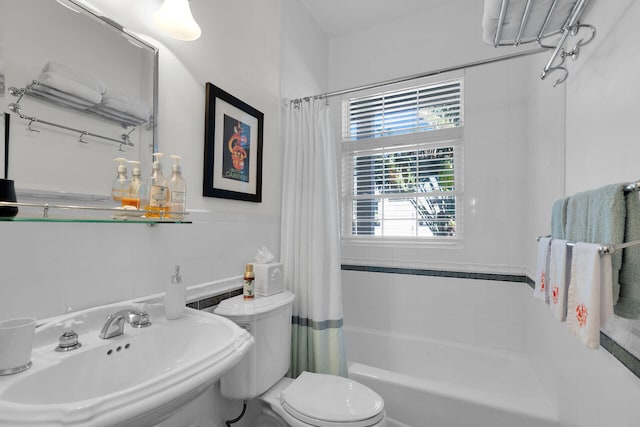 full bathroom featuring tile walls, shower / bath combination with curtain, toilet, and a sink