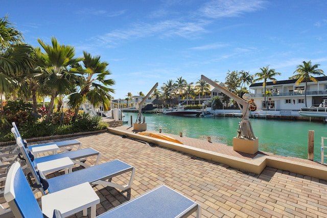 view of patio featuring boat lift, a dock, and a water view