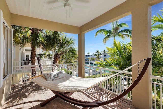 balcony with a ceiling fan and a water view