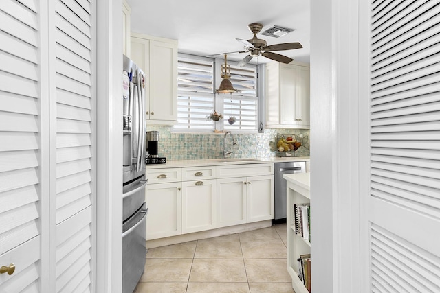 kitchen featuring stainless steel appliances, light countertops, a sink, and light tile patterned flooring