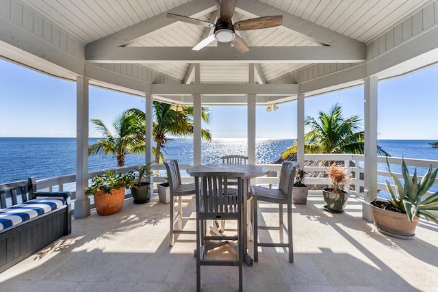 view of patio with outdoor dining space, a water view, ceiling fan, and a gazebo