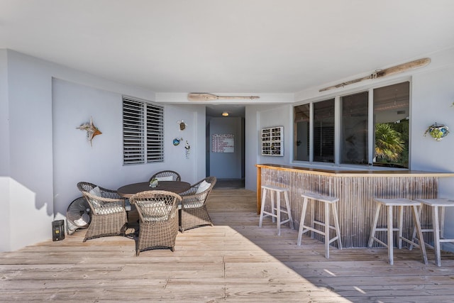 wooden deck with a bar and outdoor dining area