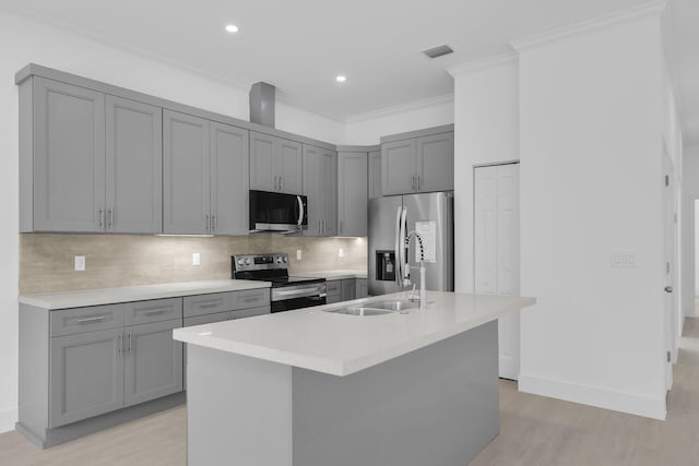 14 Tarpon Ave, Key Largo, FL 33037 - kitchen with stainless steel appliances, gray cabinets, crown molding, light wood finished floors, and tasteful backsplash