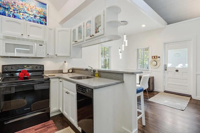 817 Terry Ln, Key West, FL 33040 - kitchen featuring a peninsula, a sink, white cabinets, light countertops, and black appliances