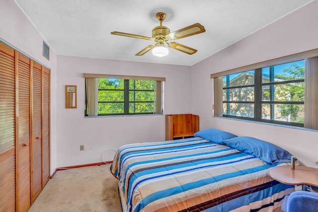 carpeted bedroom with a closet and ceiling fan