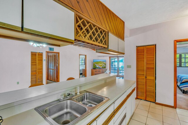 carpeted bedroom featuring multiple closets, ceiling fan, ensuite bath, and wood walls