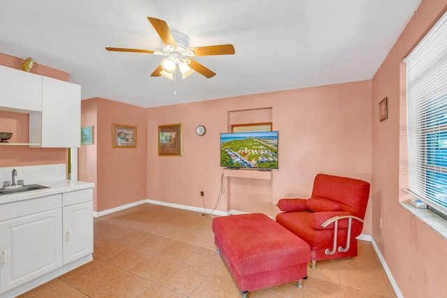 living area with sink, light tile patterned floors, and ceiling fan