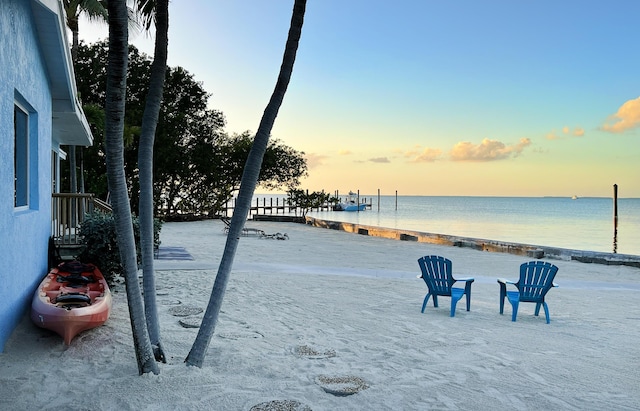 yard at dusk with a view of the beach and a water view