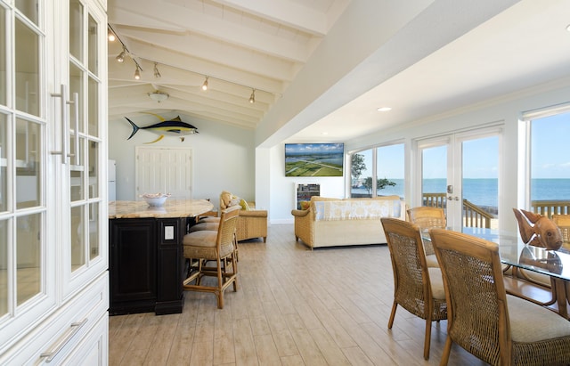 dining room featuring french doors, rail lighting, light hardwood / wood-style floors, and lofted ceiling with beams