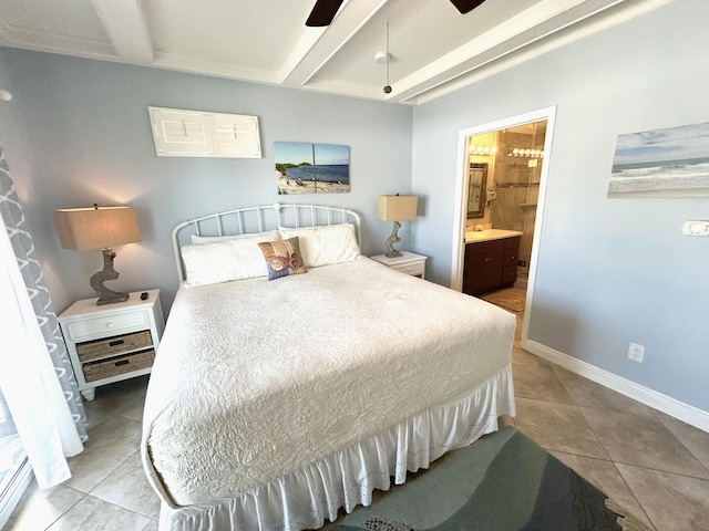 tiled bedroom with a ceiling fan, beam ceiling, baseboards, and ensuite bathroom