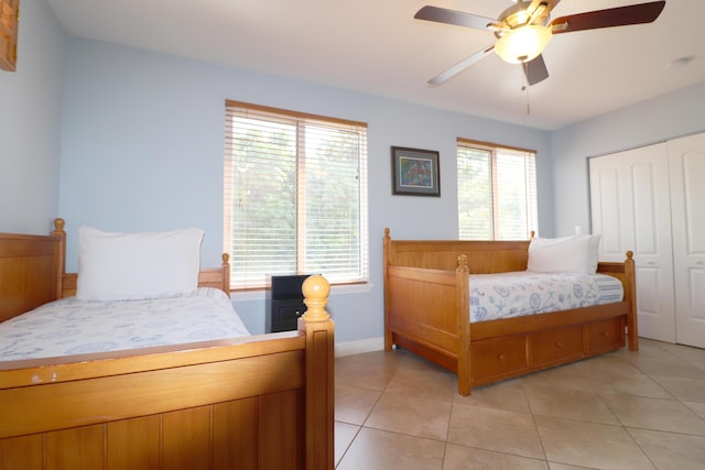 bedroom with ceiling fan, baseboards, a closet, and light tile patterned flooring