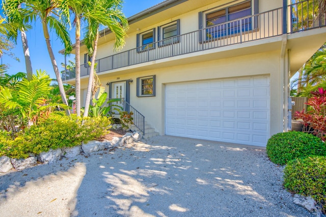 564 Sombrero Beach Rd, Marathon, FL 33050 - view of front of property featuring stucco siding, a garage, driveway, and a balcony