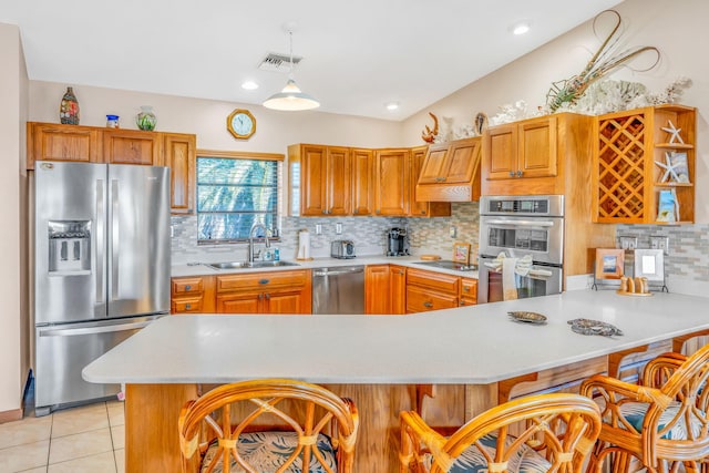 564 Sombrero Beach Rd, Marathon, FL 33050 - kitchen featuring stainless steel appliances, a sink, light countertops, a breakfast bar, and tasteful backsplash