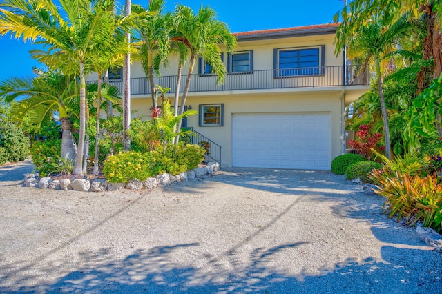 564 Sombrero Beach Rd, Marathon, FL 33050 - view of front property featuring stucco siding, a garage, dirt driveway, and stairway